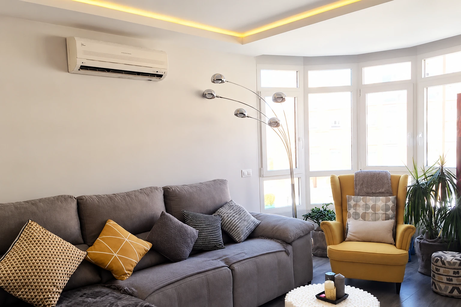 Salón con sofá gris, butaca mostaza y mirador en la vivienda de Tres Cantos.